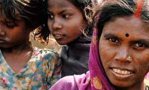 Woman looking at the camera with two girls behind